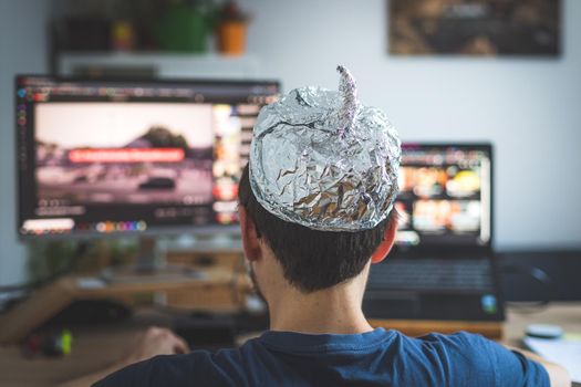 Young man is wearing aluminum cap, conspiracy theory concept