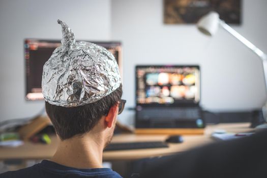 Young man is wearing aluminum cap, conspiracy theory concept
