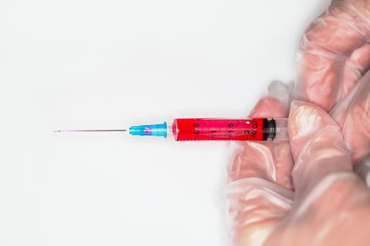 Close-up of a nurse releases air from a syringe with a medicine before injection