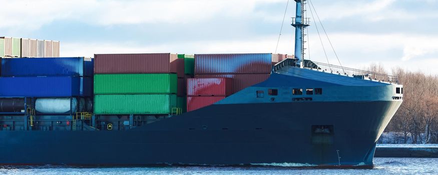 Modern grey container ship moving in still water