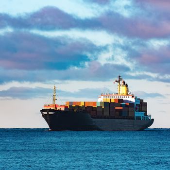 Modern black container ship moving from Baltic sea