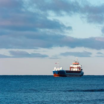 Blue bulk carrier sailing in still water