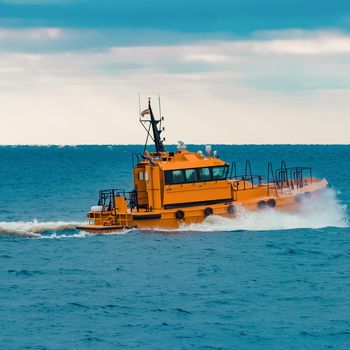 Orange pilot ship moving fast in Baltic sea. Europe