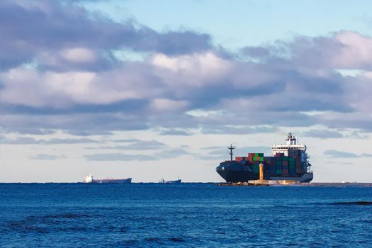 Modern grey container ship moving in still water