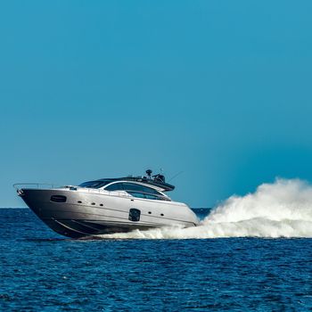 Grey speedboat moving fast by the river in Latvia. Water sport