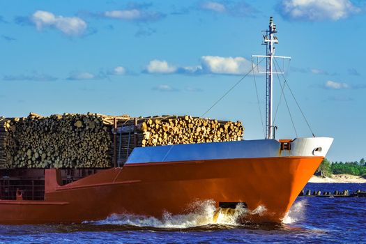 Orange bulk carrier sailing in clear summer day