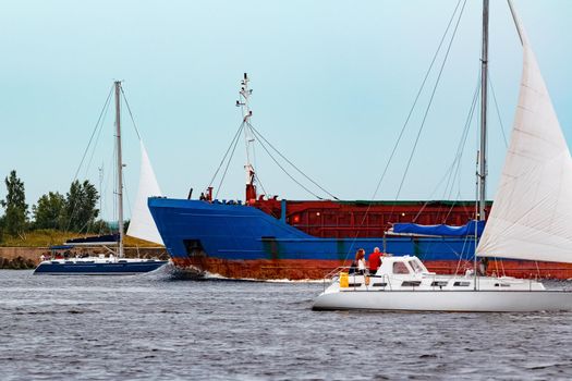 Merchandise import. Large blue cargo ship moving to Riga port