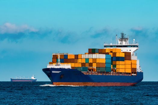 Blue container ship in travel. Logistics and freight industry