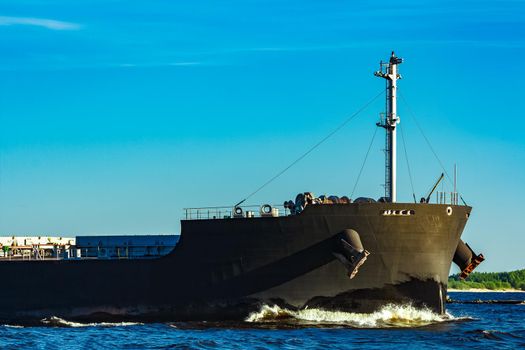 Black cargo ship moving to Baltic sea at clear day