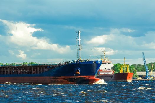 Blue bulk carrier moving in clear summer day