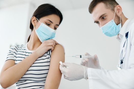 male doctor injecting vaccine into shoulder patient health coronavirus. High quality photo