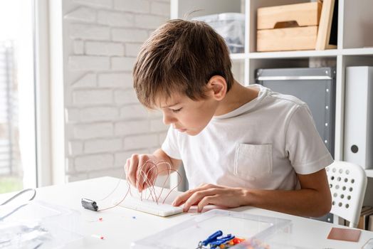 boy hands working with LED lights on experimental board for science project