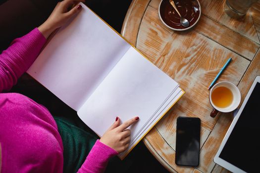 Top view of woman holding menu while going to place an order in coffee house