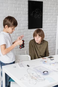 Young boys and having fun constructing robot cars together at the workshop