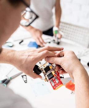 Young boys and having fun constructing robot cars together at the workshop