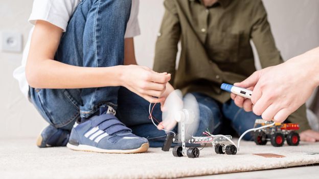 Young boys and having fun constructing robot cars together at the workshop