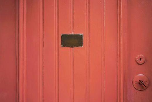 a painted wooden door with a brass plate.