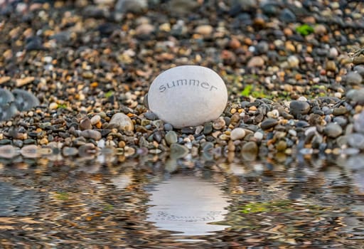Large stone on the shore of the pond with the inscription summer .
