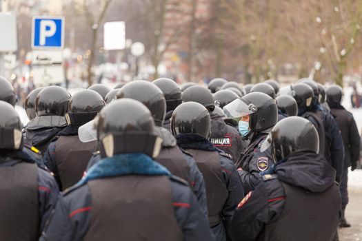 TULA, RUSSIA - JANUARY 23, 2021: Public mass meeting in support of Alexei Navalny, many police officers wearing gloss black kolpak-1SB helmets waiting for the command to arrest the protesters.