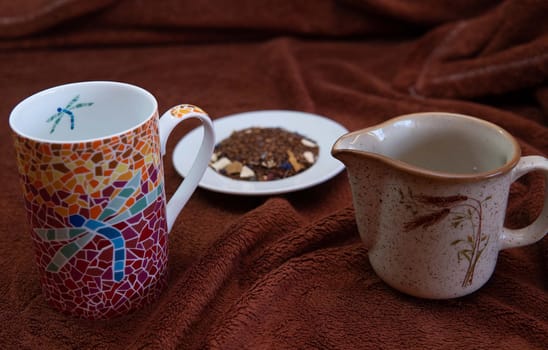 Natural tea, colorful cup and milk jug