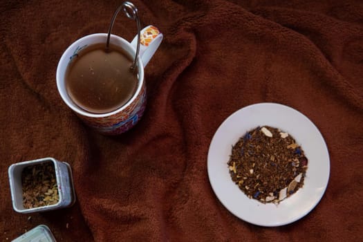 Making a tea in a colorful cup and a white saucer with natural tea