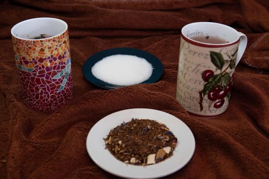 Dish with sugar and another with natural tea and two cups to drink it