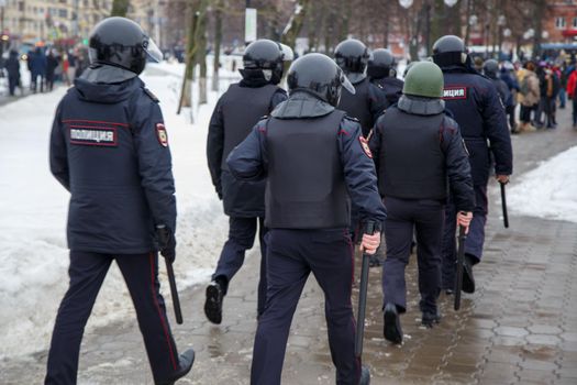 TULA, RUSSIA - JANUARY 23, 2021: Public mass meeting in support of Alexei Navalny, group of police officers going to arrest protesters. View from back.