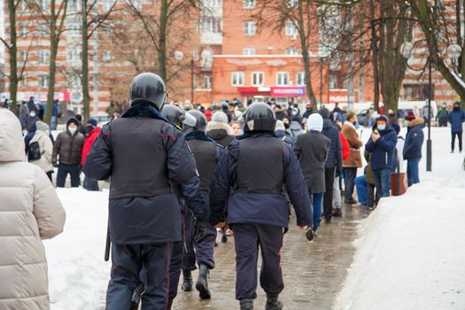 TULA, RUSSIA - JANUARY 23, 2021: Public mass meeting in support of Alexei Navalny, group of police officers going to arrest protesters. View from back.