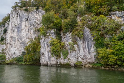 Danube river at Danube breakthrough near Kelheim, Bavaria, Germany in autumn with limestone rock formations and plants with colorful leaves