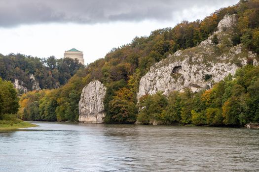 Nature reserve at Danube river breakthrough near Kelheim, Bavaria, Germany in autumn with limestone rock formations and Befreiungshalle on the Michelsberg in the background