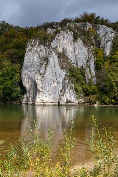 Danube river at Danube breakthrough near Kelheim, Bavaria, Germany in autumn with limestone rock formations and plants with colorful leaves