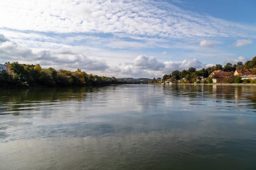 View at Danube shore in Passau during a ship excursion in autumn with multicolored trees 