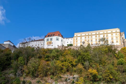 View at fortress Veste Oberhaus in Passau during a ship excursion in autumn with colorfull trees