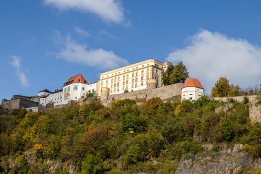 View at fortress Veste Oberhaus in Passau during a ship excursion in autumn with colorfull trees