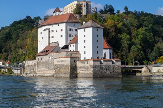 View at fortress Veste Oberhaus in Passau during a ship excursion in autumn with colorfull trees