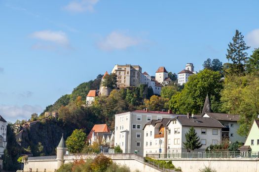 View at fortress Veste Oberhaus in Passau during a ship excursion in autumn with colorfull trees