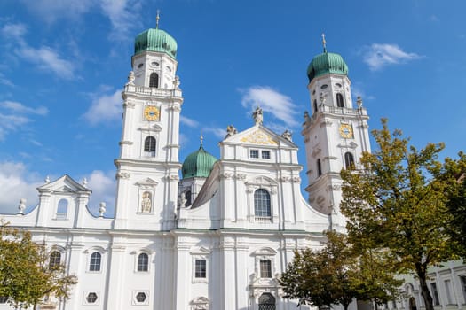 The front of St. Stephen's Cathedral (Dom St. Stephan) in Passau, Bavaria, Germany in autumn with multicolored trees in foregound