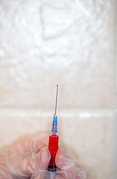 Close-up of a nurse releases air from a syringe with a medicine before injection