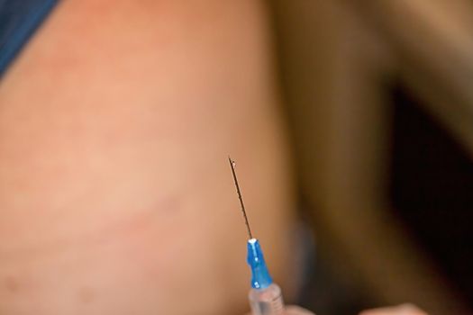 Close-up of a nurse releases air from a syringe with a medicine before injection