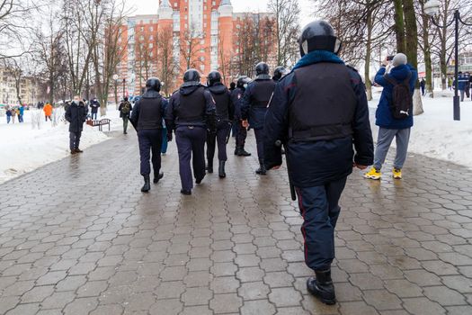 TULA, RUSSIA - JANUARY 23, 2021: Public mass meeting in support of Alexei Navalny, group of police officers going to arrest protesters. View from back.