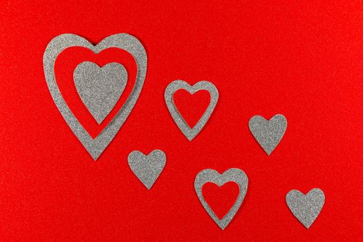 Saint Valentine's day love themed flat-lay design red and silver hearts on textured red background