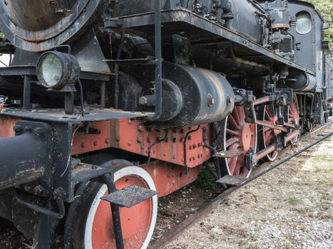 Red and black vintage train standing on rails. Old steam locomotive.