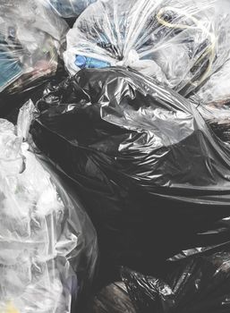 Garbage bags. Piles of garbage in plastic bin bags. Landfill. Close-up for background. Retro style photo.