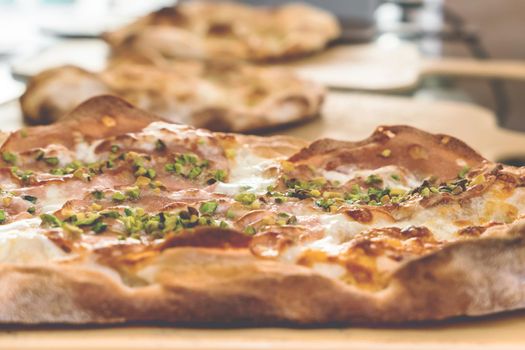 Delicious gourmet pizza with ham, and pistachios.