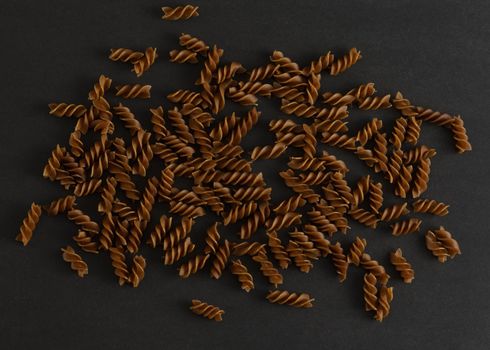 Flat lay with uncooked buckwheat pasta on black background. Concept of dieting, gluten free food, wellness and healthy lifestyle. High quality photo