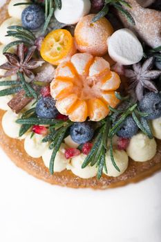 Christmas or New Year decorated cake with cream cheese frosting and cranberries