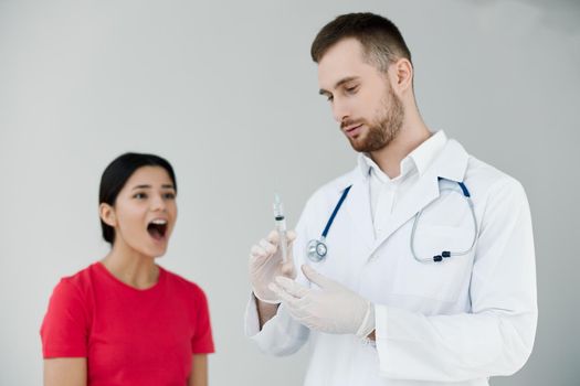 woman with open mouth is afraid of injections near the doctor. High quality photo