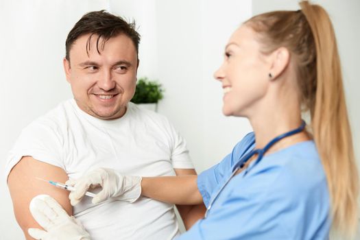 male patient next to doctor woman injection health. High quality photo