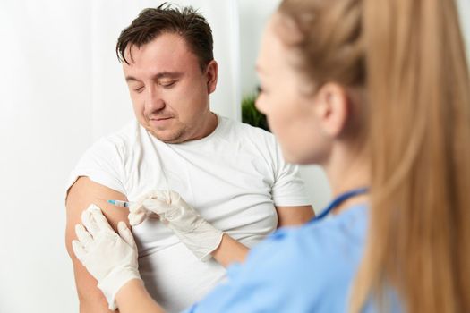 a doctor gives an injection to a man's hand health vaccination. High quality photo