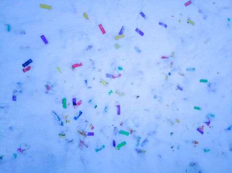 Colorful confetti glitter on the snow after holiday. No plastic, eco living concept.
